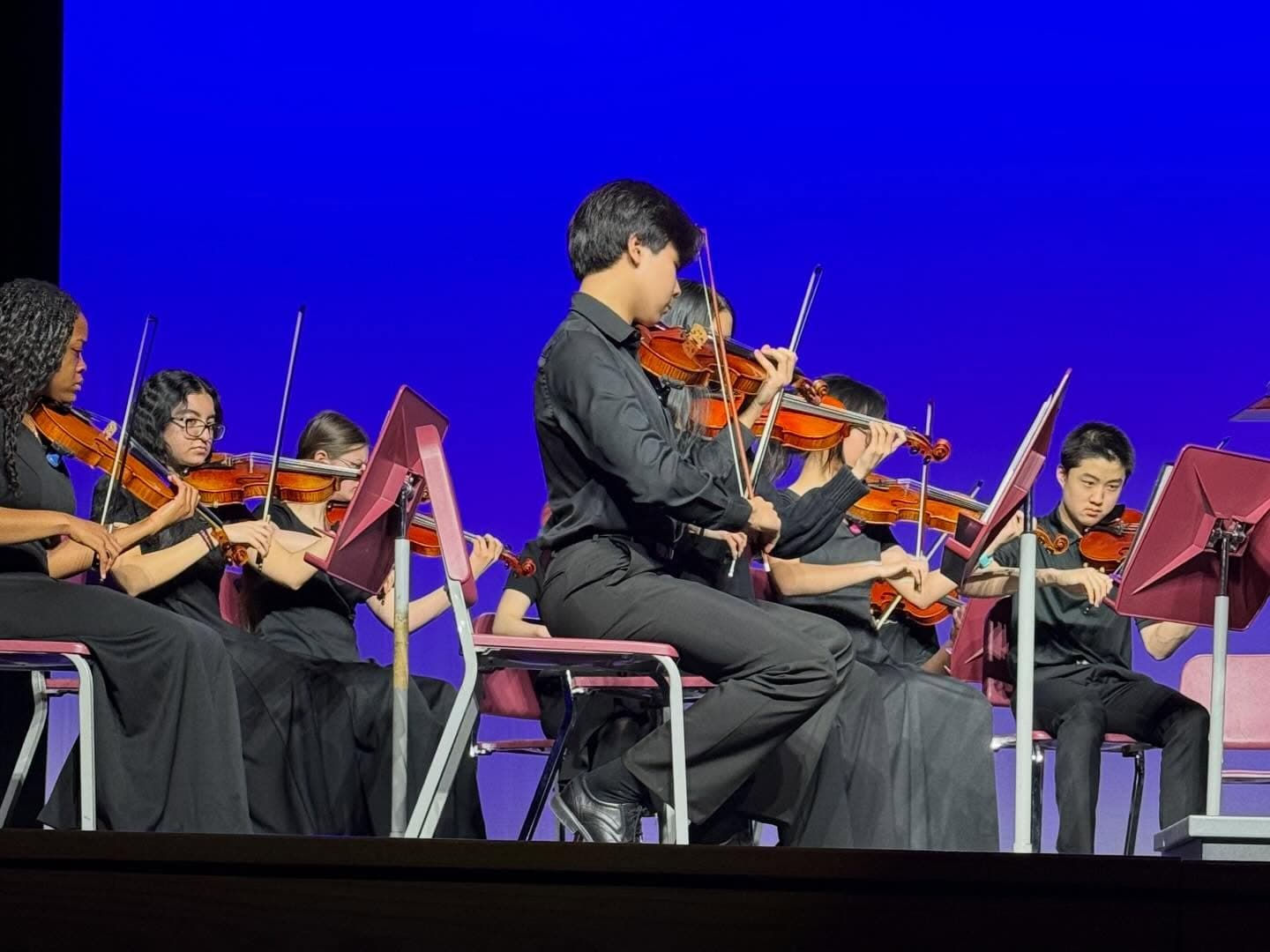 Munster violinists performing on the Munster High School Auditorium stage